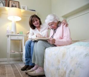 badante che aiuta anziana a leggere